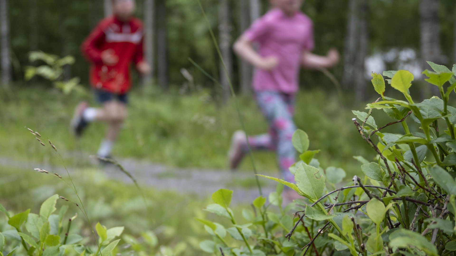 Två barn springer på elljusspår