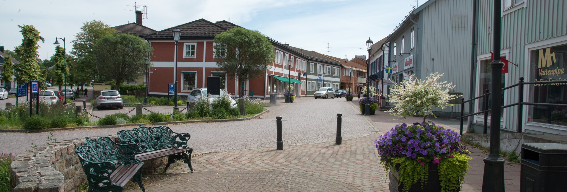 Gågata med kullersten, trähus och blomsterlådor