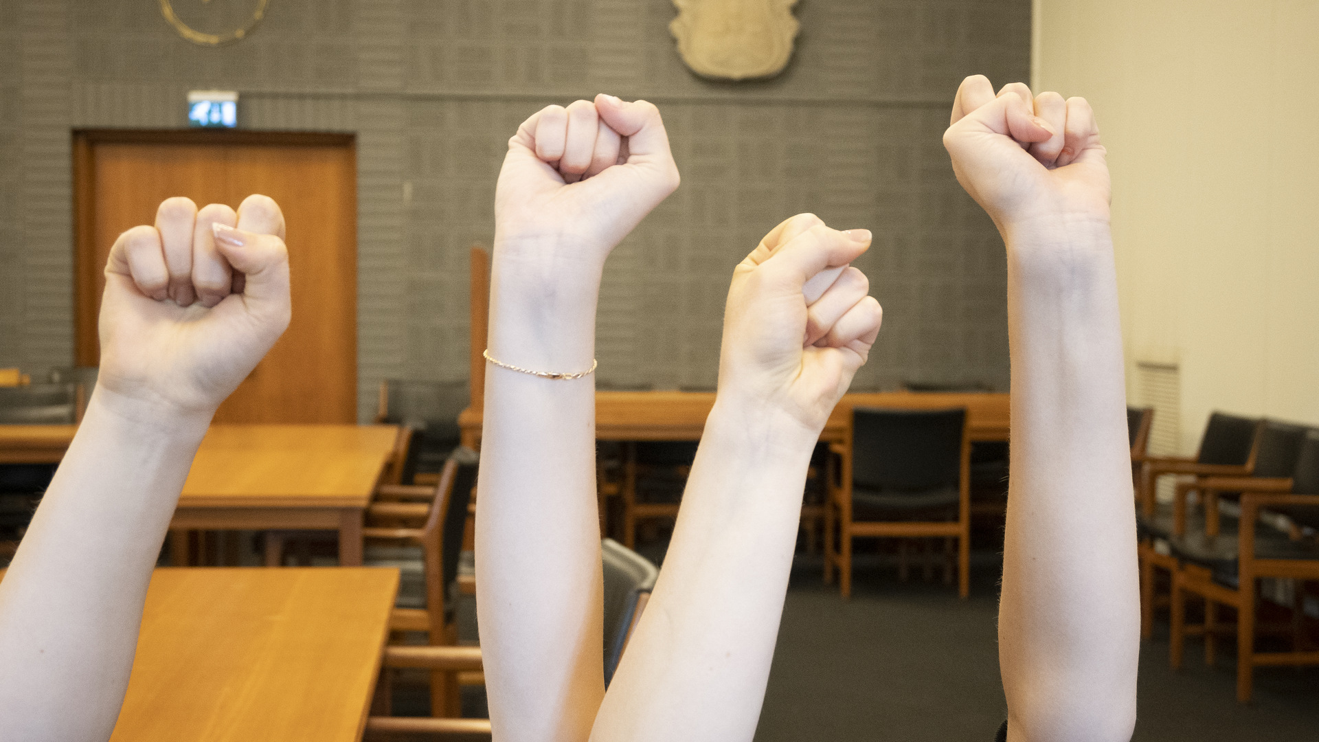 Fyra knutna händer i luften.