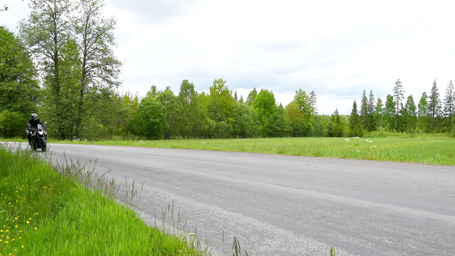 Carl Winblad åker motorcykel på vacker väg.