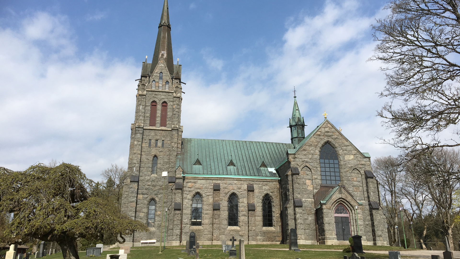 Gotisk stenkyrka med grön tak.