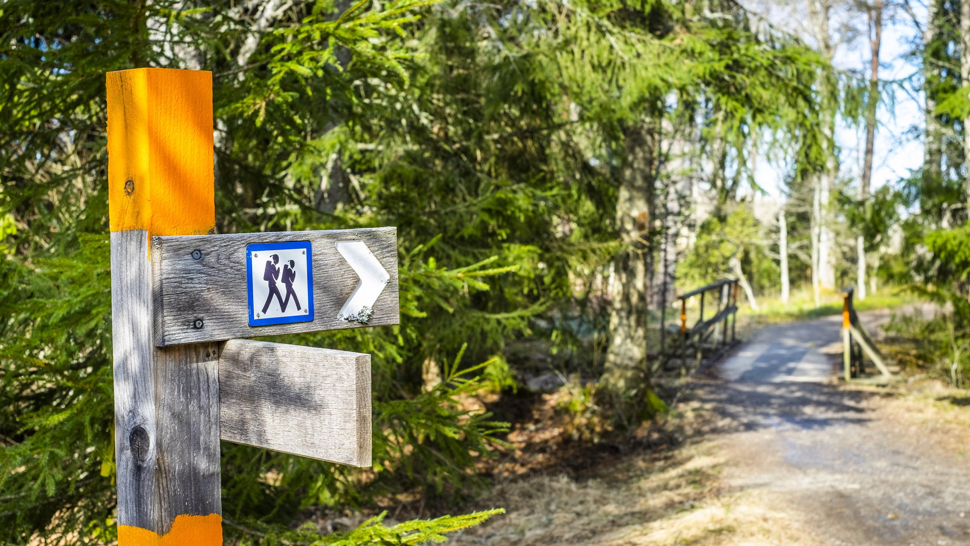 Orangefärgad stolpe med symbol för vandrare-