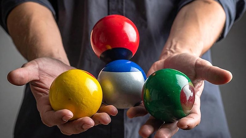 händer som jonglerar med färgglada bollar