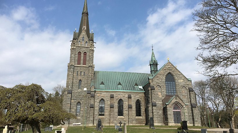 Gotisk stenkyrka med grön tak.