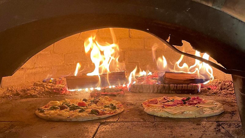 Pizzor i vedeldad öppen ugn.