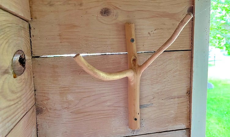 Klädhängare i snidat trä på en vägg.