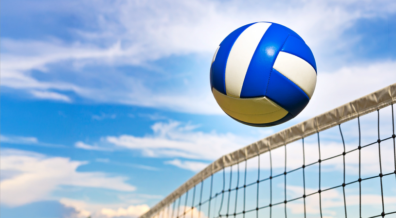 Volleyboll flyger över nät.