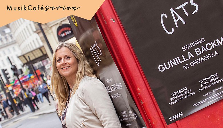 Kvinna står lutad mot reklampelare i London.